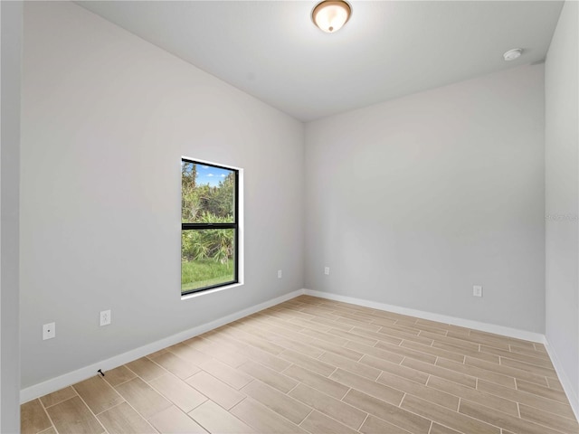 unfurnished room with light wood-type flooring and baseboards