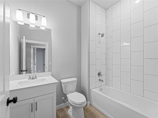 full bath with toilet, wood finish floors, vanity, baseboards, and washtub / shower combination