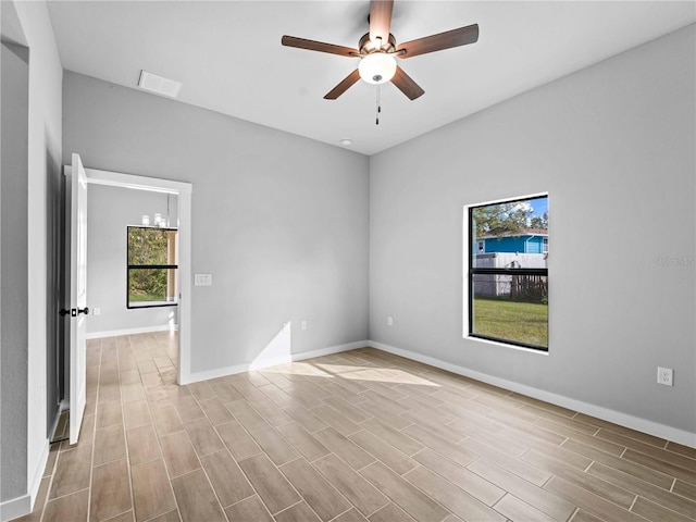 unfurnished room featuring ceiling fan, baseboards, and wood tiled floor