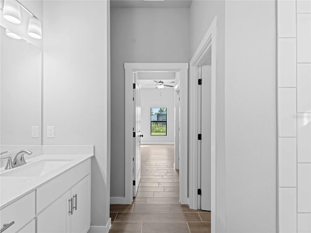 bathroom with ceiling fan, baseboards, and vanity