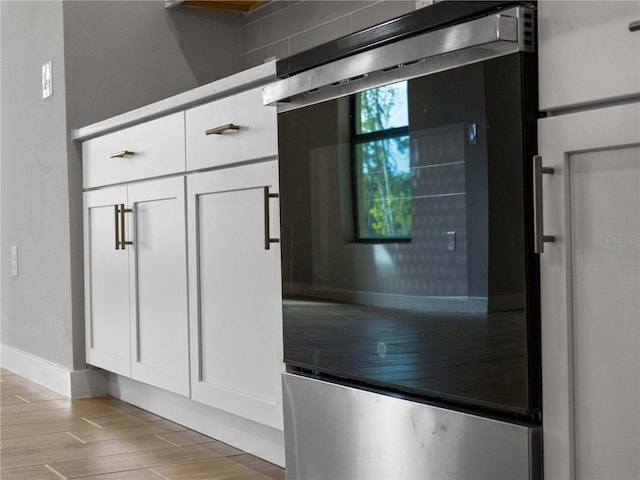 details with wine cooler, white cabinetry, and wood tiled floor