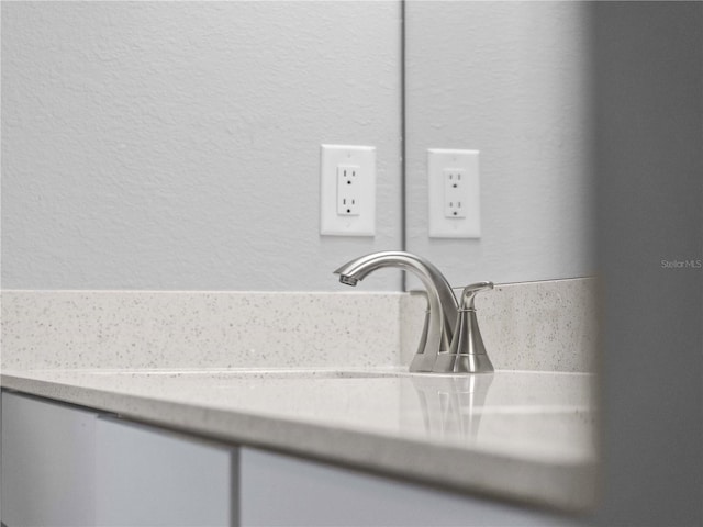 interior details featuring vanity and a textured wall