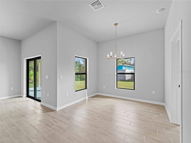 empty room with a chandelier, visible vents, plenty of natural light, and baseboards