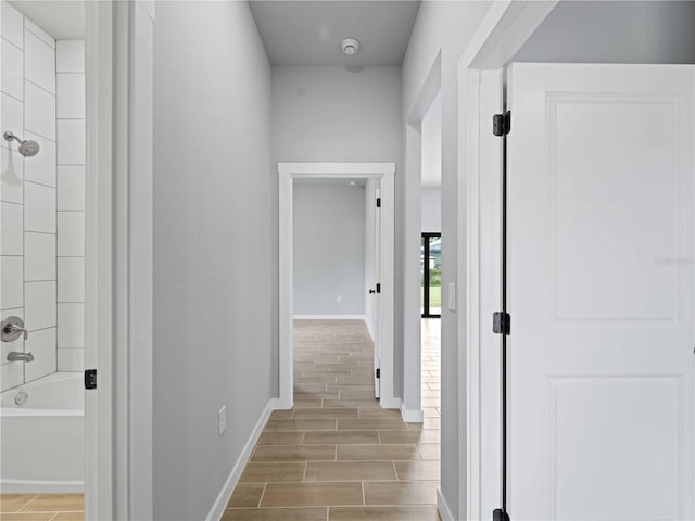 corridor with wood finish floors and baseboards