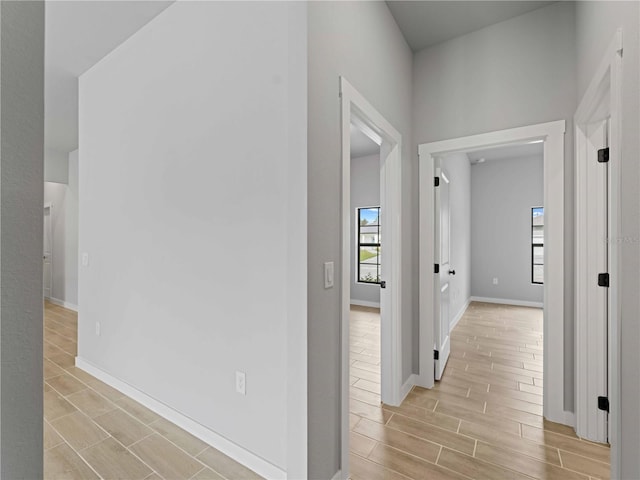 corridor featuring baseboards and wood tiled floor