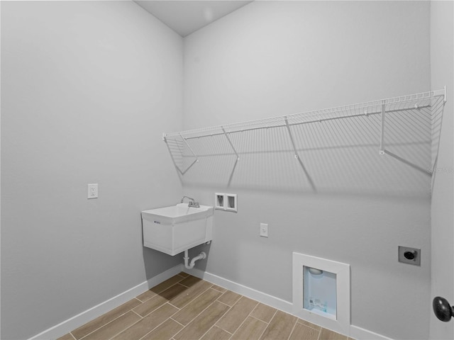 clothes washing area featuring washer hookup, wood finish floors, hookup for an electric dryer, laundry area, and baseboards