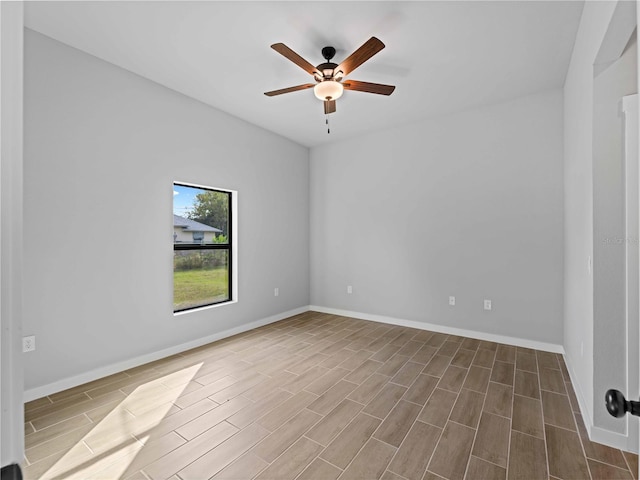 spare room with a ceiling fan, baseboards, and wood finished floors