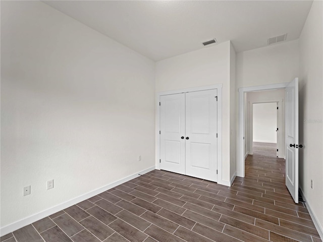 12156 Wellington Ave, Port Charlotte, FL 33981 - unfurnished bedroom with dark wood finished floors, baseboards, and a closet