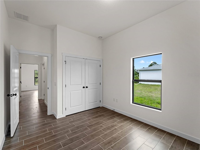 12156 Wellington Ave, Port Charlotte, FL 33981 - unfurnished bedroom with baseboards, dark wood-style flooring, and a closet