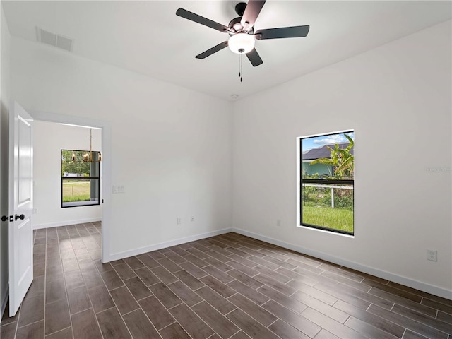 12156 Wellington Ave, Port Charlotte, FL 33981 - empty room with healthy amount of natural light, wood tiled floors, and baseboards