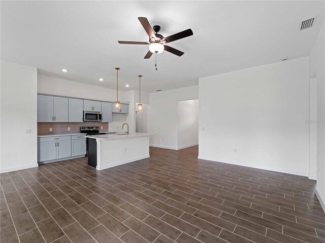 12156 Wellington Ave, Port Charlotte, FL 33981 - kitchen featuring stainless steel appliances, open floor plan, a sink, light countertops, and recessed lighting
