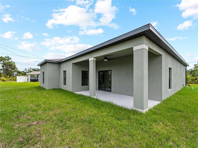 12156 Wellington Ave, Port Charlotte, FL 33981 - back of property featuring stucco siding, a ceiling fan, a patio area, and a lawn