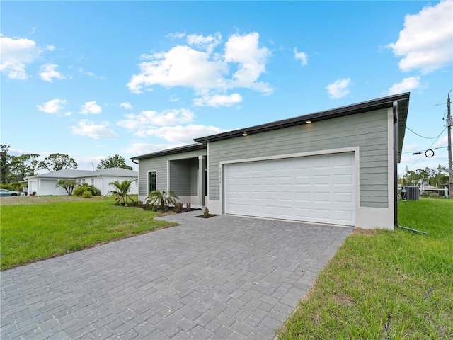 12156 Wellington Ave, Port Charlotte, FL 33981 - view of front facade featuring central AC, a front lawn, decorative driveway, and an attached garage