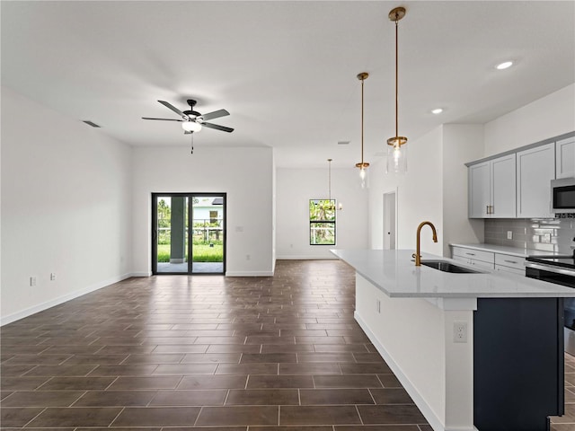 12156 Wellington Ave, Port Charlotte, FL 33981 - kitchen with a sink, appliances with stainless steel finishes, open floor plan, ceiling fan, and a kitchen island with sink