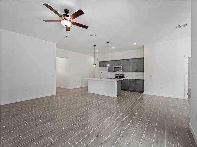 kitchen featuring visible vents, open floor plan, gray cabinets, stainless steel appliances, and a sink