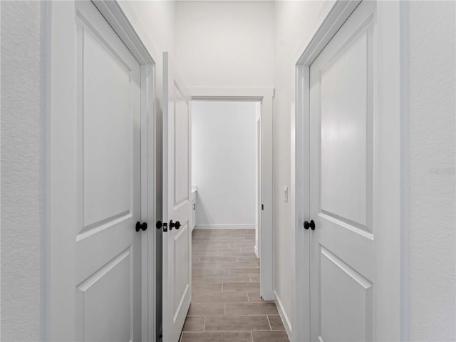 corridor featuring wood finish floors and baseboards