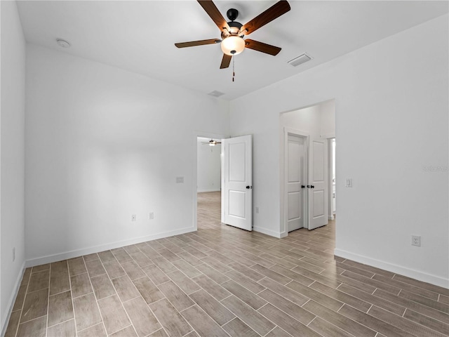 unfurnished room with visible vents, ceiling fan, baseboards, and wood finished floors