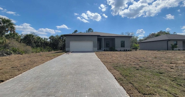 ranch-style house with an attached garage and decorative driveway