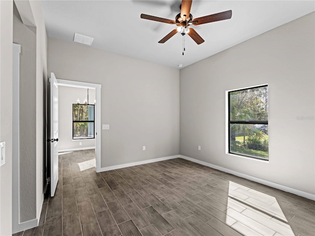 unfurnished room featuring dark wood-style flooring, visible vents, ceiling fan, and baseboards