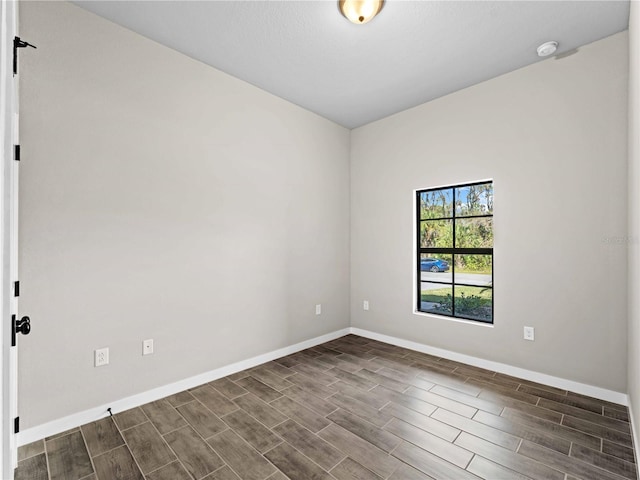 spare room featuring wood tiled floor and baseboards