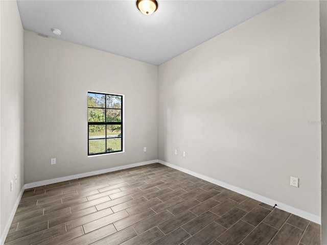 spare room featuring baseboards and wood finish floors