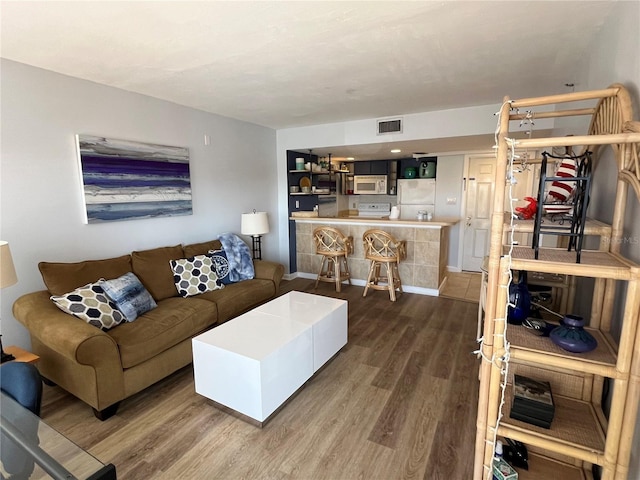 living area featuring visible vents and dark wood finished floors