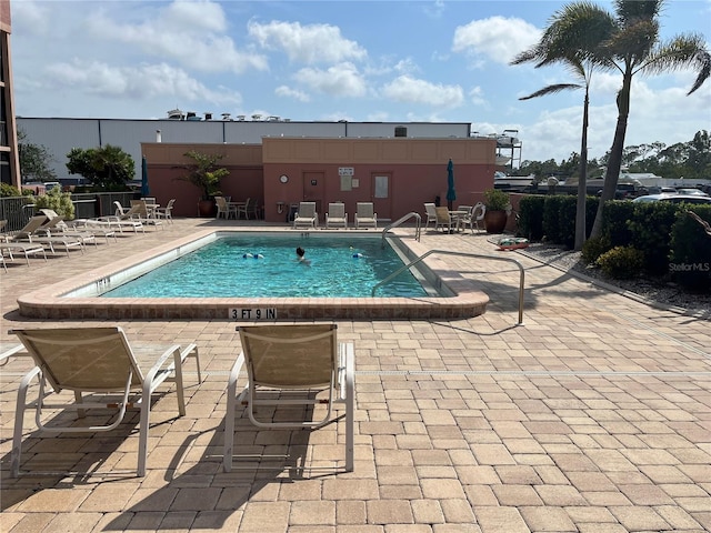 pool with a patio and fence