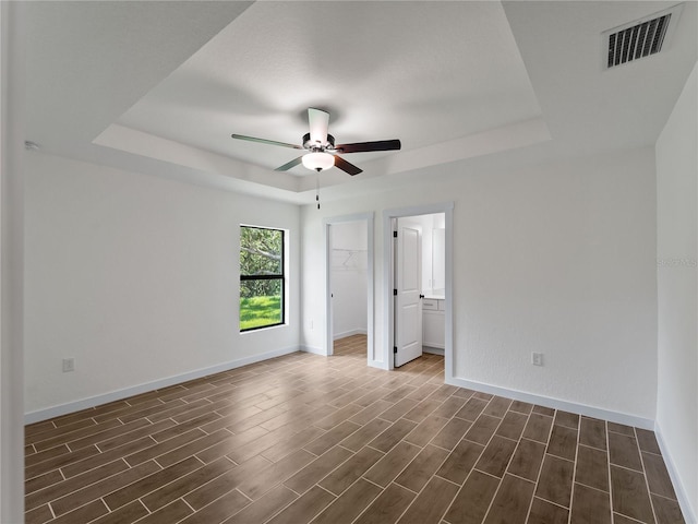 17331 Elmwood Ave, Port Charlotte, FL 33948 - unfurnished room with a tray ceiling, ceiling fan, and dark wood-style floors