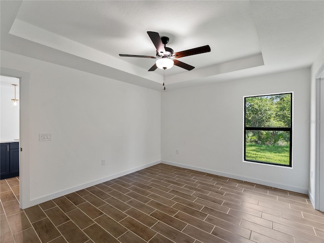 17331 Elmwood Ave, Port Charlotte, FL 33948 - spare room featuring a raised ceiling, ceiling fan, and dark wood finished floors