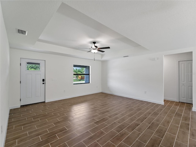 17331 Elmwood Ave, Port Charlotte, FL 33948 - unfurnished room with a raised ceiling, dark wood-style flooring, and ceiling fan