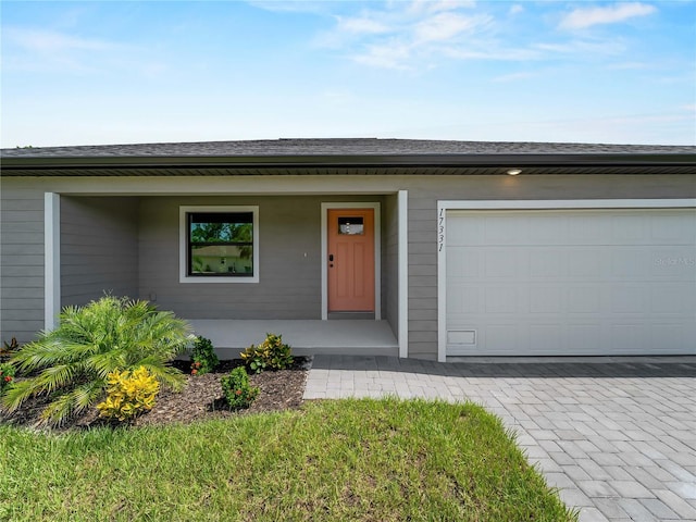 17331 Elmwood Ave, Port Charlotte, FL 33948 - view of front facade with a porch, roof with shingles, and decorative driveway