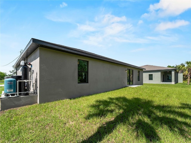 17331 Elmwood Ave, Port Charlotte, FL 33948 - rear view of house with stucco siding and a lawn
