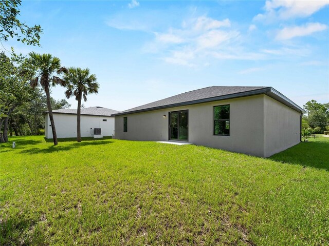 17331 Elmwood Ave, Port Charlotte, FL 33948 - back of house with a yard and stucco siding
