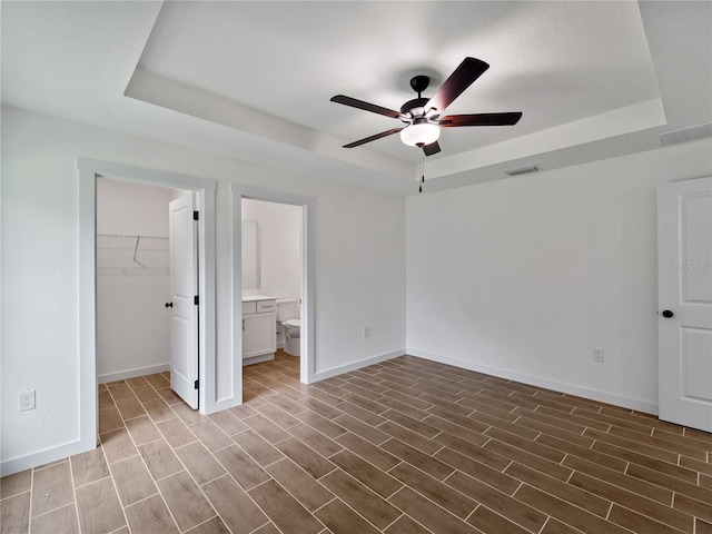 17331 Elmwood Ave, Port Charlotte, FL 33948 - unfurnished bedroom featuring a tray ceiling, wood finished floors, a spacious closet, and ceiling fan