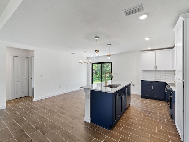 17331 Elmwood Ave, Port Charlotte, FL 33948 - kitchen featuring blue cabinets, backsplash, a chandelier, light countertops, and stainless steel dishwasher