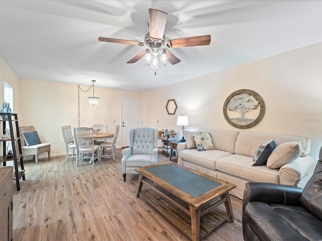 living room featuring ceiling fan, baseboards, and light wood-style floors