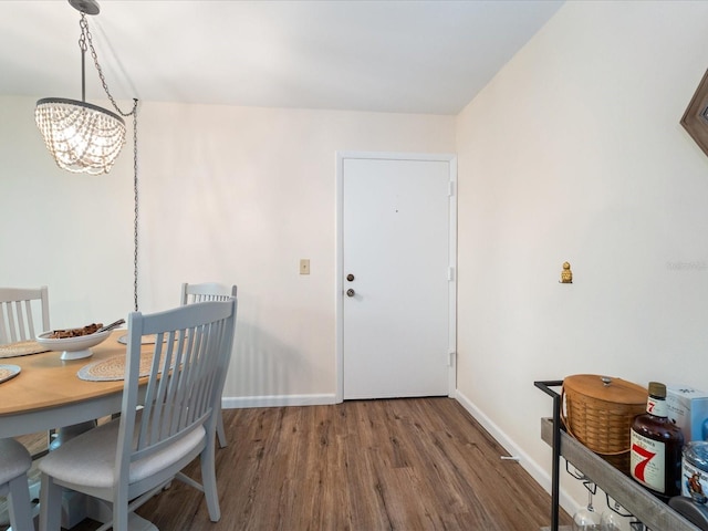 dining room featuring baseboards, a notable chandelier, and wood finished floors