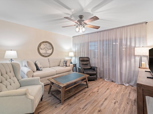 living area with light wood-style floors and ceiling fan