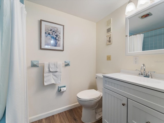 bathroom with visible vents, baseboards, toilet, wood finished floors, and vanity