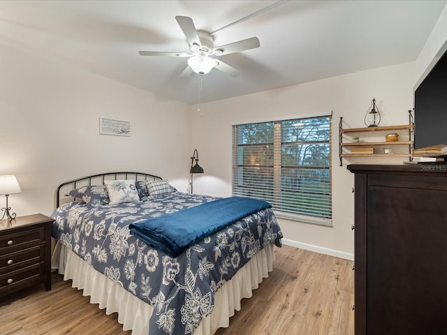 bedroom with light wood-type flooring, baseboards, and a ceiling fan