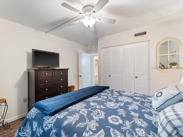 bedroom featuring visible vents, baseboards, ceiling fan, wood finished floors, and a closet