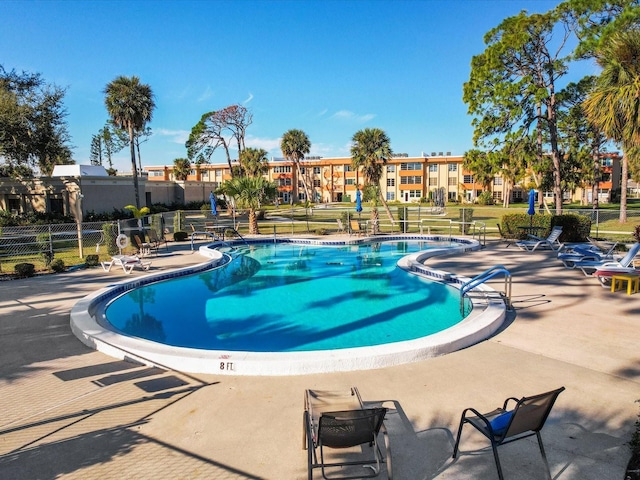 view of swimming pool with a patio area and fence