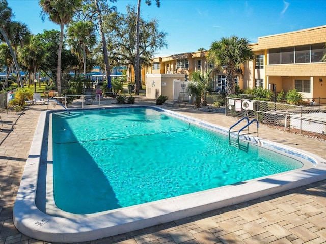 community pool featuring a patio and fence