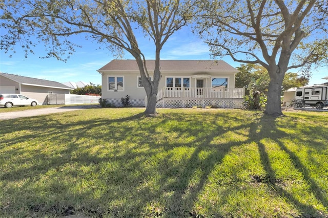 ranch-style home featuring a front lawn, a wooden deck, and fence