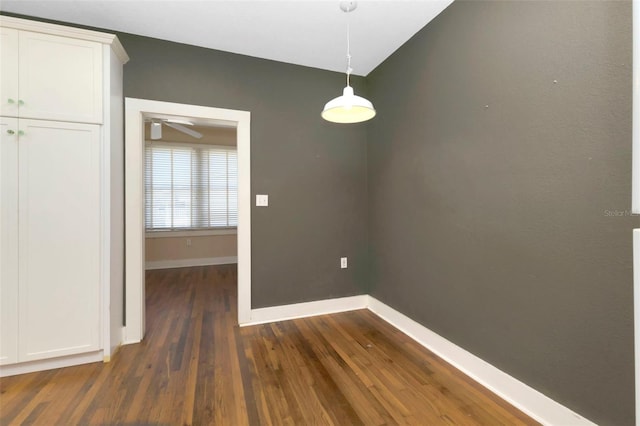 unfurnished dining area featuring dark wood finished floors, baseboards, and ceiling fan