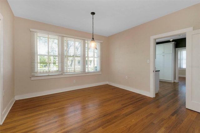 empty room with baseboards and wood finished floors