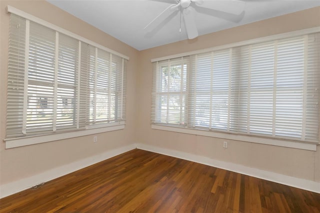 empty room featuring wood finished floors, a ceiling fan, and baseboards