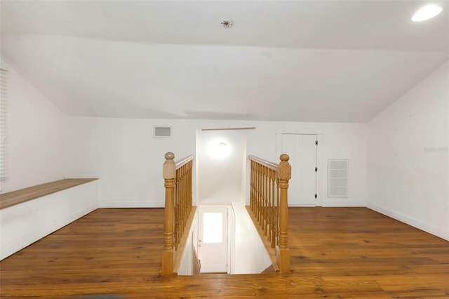 bonus room featuring lofted ceiling, baseboards, visible vents, and hardwood / wood-style floors