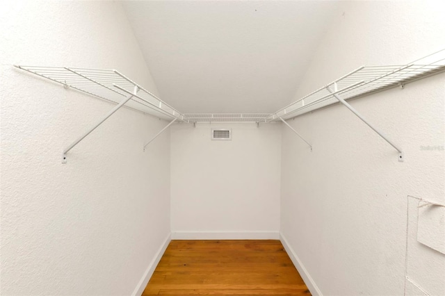 spacious closet featuring wood finished floors and visible vents