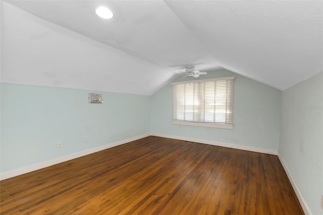 bonus room featuring lofted ceiling, ceiling fan, dark wood-type flooring, and baseboards